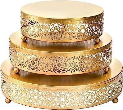 Decorative gold metal round cake stand set with ornate floral cutwork for wedding dessert display