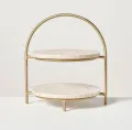 Round marble 2-tier serving stand with handcrafted brass frame for luxury dining and home décor.